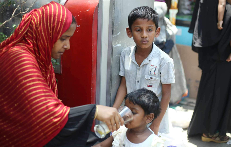 বাইরে বের হয়ে অতি গরমে তৃষ্ণার্ত শিশুদের শরবত খাওয়াচ্ছেন অভিভাবকরা। ছবি: মাহবুব আলম