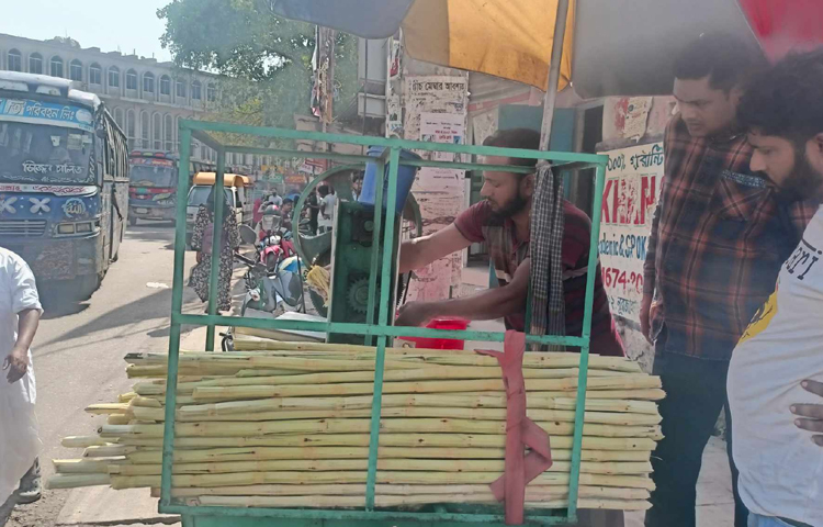 ব্যস্ত দোকানি। আর আখের রসে তৃষ্ণা মেটানোর আশায় অপেক্ষা করছেন ক্রেতারা। ছবি: মফিজুল সাদিক