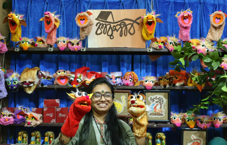 হস্তশিল্পের নানা পণ্য নিয়ে দোকান সাজিয়েছেন তরুণী। ছবি: মাহবুব আলম