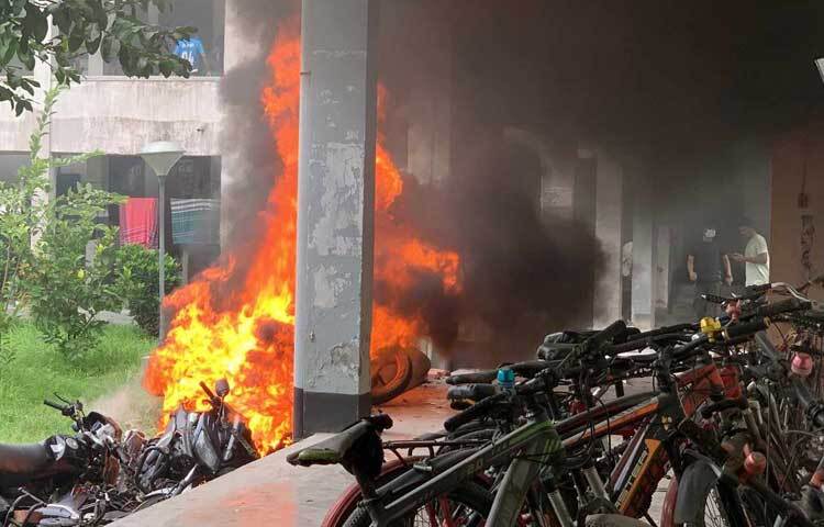 জানা গেছে, বিকেল ৩টার দিকে রাবিতে লাঠিসোঁটা নিয়ে প্রবেশ করেন আন্দোলনকারীরা। এরপর বিশ্ববিদ্যালয়ের বঙ্গবন্ধু হলের নিচতলায় থাকা ১০-১৫টি মোটরসাইকেলে আগুন দেন তারা। ছবি: সাখাওয়াত হোসেন