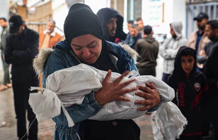 সন্তানের মরদেহ কোলে কাঁদছেন মা। ছবি: এএফপি