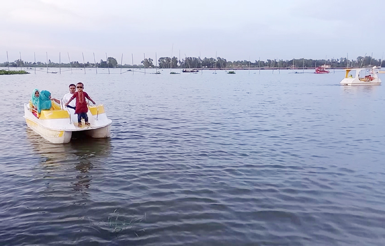 অন্যদিকে নদীর কূলে গড়ে উঠেছে ‘ভাসমান রেঁস্তোরা’। বাঁধানো ঘাটজুড়ে অর্ধশতাধিক নৌকাও থাকে বিকেল থেকে রাত পর্যন্ত। আছে প্লাস্টিকের প্যাডেল বোটও। বেড়াতে আসা লোকজন সেগুলো ভাড়া করে হুরাসাগর নদে বেড়াতে যান। ছবি: আমিন ইসলাম জুয়েল