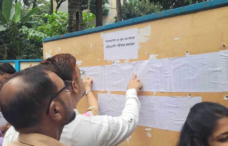 নোটিশ বোর্ডে সন্তানের রেজাল্ট খোঁজতে ব্যস্ত বাবা। ছবি: মাহবুব আলম
