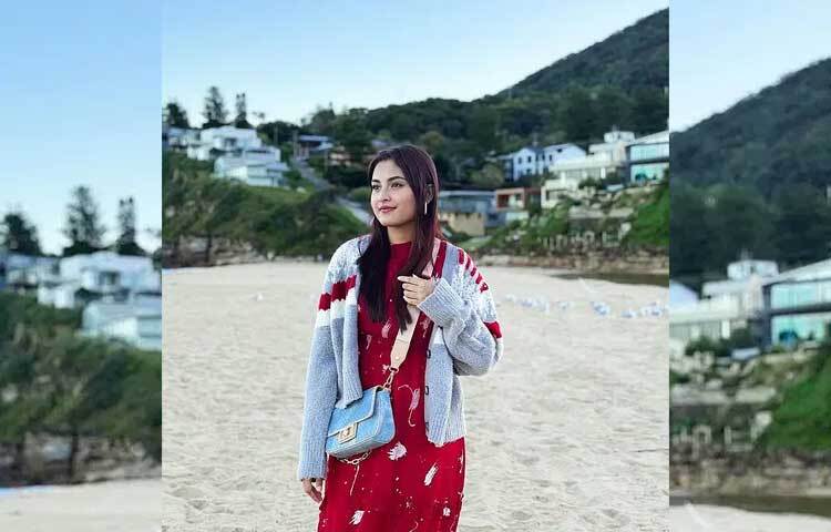 লাল মিডি ড্রেসের ওপর ধূসর-লাল রঙের সোয়েটারে বেশ স্টাইলিশ লাগছে অভিনেত্রীকে।