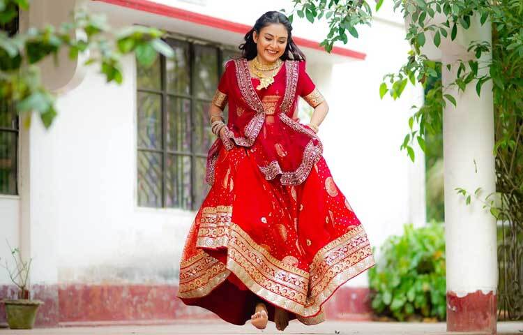 লাল লেহেঙ্গায় হাস্যোজ্জ্বল নায়িকা।