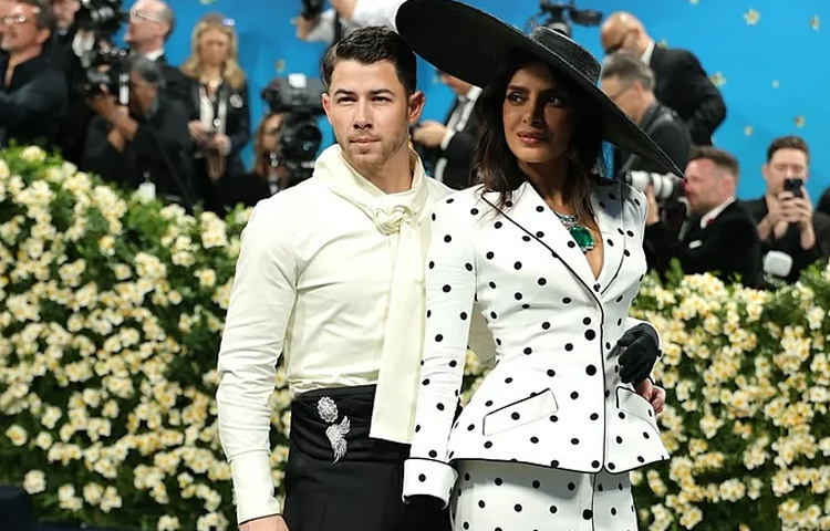 প্রিয়াঙ্কার সঙ্গে মিলিয়ে সাদা ফিটেড শার্ট আর হাই ওয়েস্ট কালো প্যান্ট ও কালো ড্রেস সুজ পরেছেন গায়ক স্বামী নিক জোনাস।