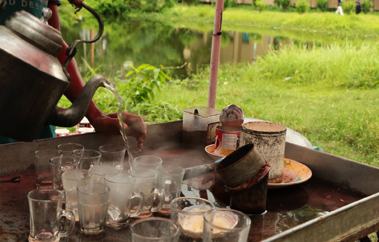 খোলা আকাশ, ধোঁয়াভরা বাতাস, আর কাচের কাপ মিলে তৈরি হয় অন্য রকম এক পরিবেশ।