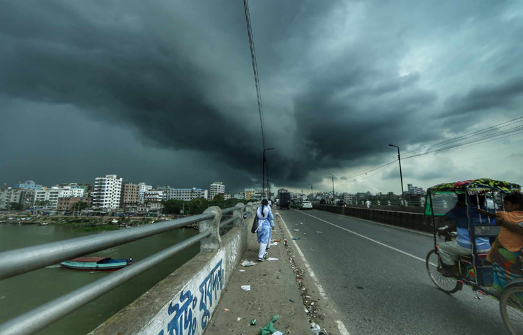 বাবুবাজার ব্রিজ থেকে দেখা সেই দৃশ্য শুধু ছবি নয়, এক শহুরে আবেগ। গরমে ক্লান্ত মানুষের মনে হঠাৎ পাওয়া কিছু প্রশান্তির মুহূর্ত। এই বৃষ্টি কেবল শরীর ঠান্ডা করে না, মনকেও ছুঁয়ে যায় নীরবে।