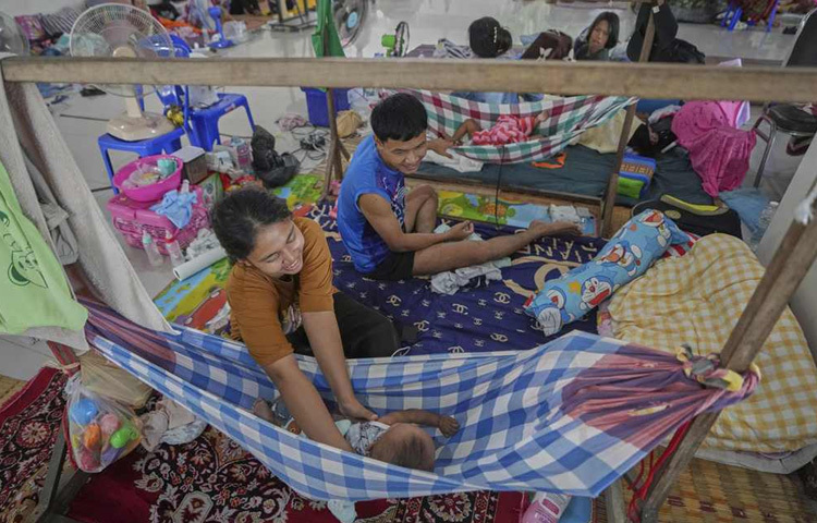 থাই ও কম্বোডিয়ান সৈন্যদের মধ্যে সংঘর্ষের পর বাড়ি থেকে পালিয়ে আসা তাদের বাচ্চাদের দেখাশোনা করছে থাই পরিবার।