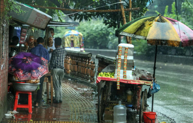 রমনা এলাকার ফুটপাত দিয়ে হাঁটতে হাঁটতে চোখে পড়ে-প্লাস্টিক দিয়ে ঢেকে রাখা দোকান, তাতেও বৃষ্টির পানি ঢুকে ভিজিয়ে দিয়েছে জামা-কাপড়, খেলনা আর নিত্যপ্রয়োজনীয় জিনিসপত্র। যে দোকানে দুপুরে খানিক ভিড় হতো, সেখানে আজ ক্রেতা নেই বললেই চলে। পাশেই এক দোকানদার দাঁড়িয়ে আছেন ছাতার নিচে, অসহায় চোখে তাকিয়ে আছেন তার ভিজে যাওয়া পণ্যের দিকে।