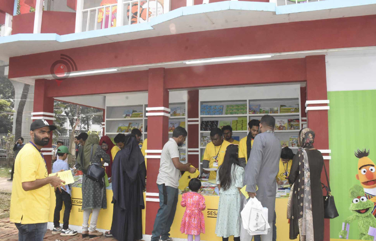 বইমেলার বিভিন্ন স্টলে ঘুরে ঘুরে বই দেখছেন এক বিদেশি নারী। ছবি: বিপ্লব দীক্ষিত