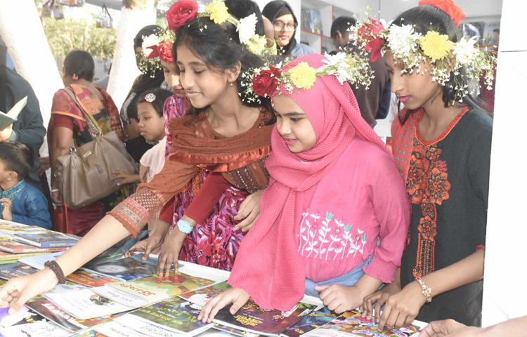 শাহবাগ থেকে টিএসসি পর্যন্ত সড়কের ফুটপাতে মৌসুমি ফুল দিয়ে তৈরি করা রিং নিয়ে হাজির ছিলেন বিক্রেতারা। সেই রিং মাথায় দিয়ে বাঁ হাত ও খোঁপায় গাঁদা-বেলির মালা জড়িয়ে মেলায় এসেছেন নারীরা। ছবি: বিপ্লব দীক্ষিত