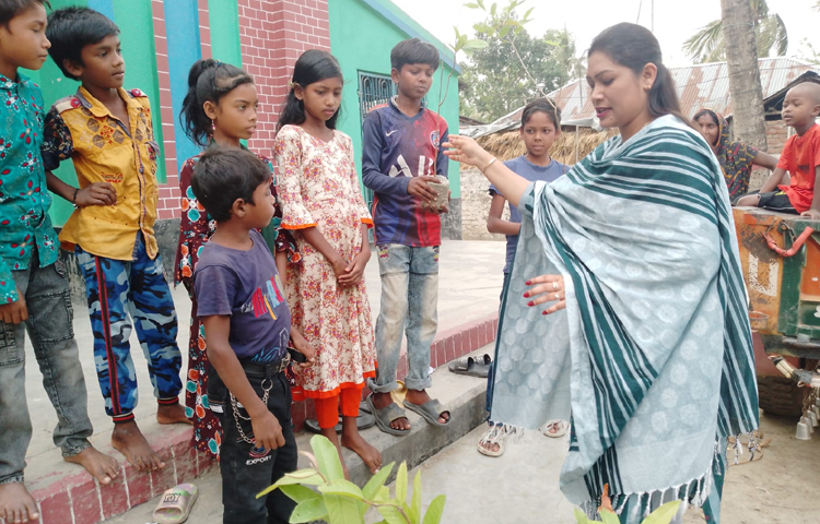 প্রায় শতাধিক কোমলমতি শিশুদের হাতে গাছ তুলে দেন সংস্থার পরিচালক সুমি মুর্ম। ছবি: জাগো নিউজ