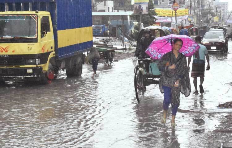 রাস্তায় জমে থাকা ময়লা পানির মধ্যেই হেঁটে গন্তব্যে যাচ্ছেন সবাই। ছবি: বিপ্লব দীক্ষিত