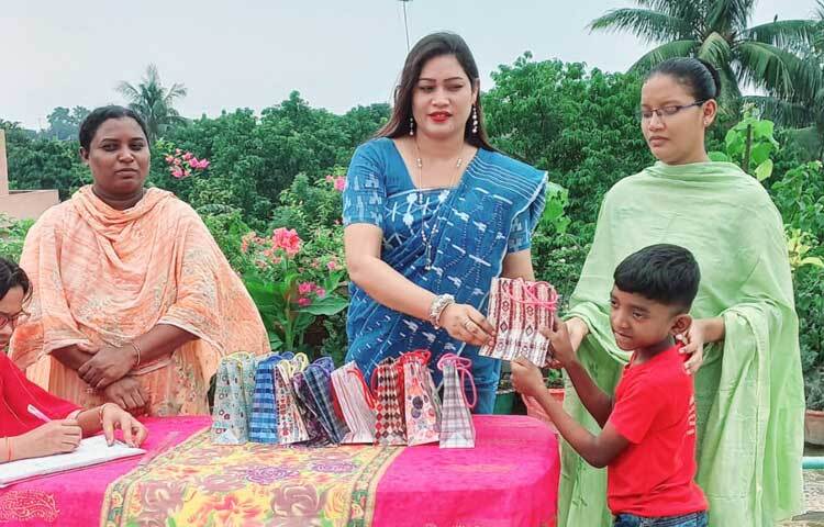 শিক্ষাভাতা ও উপহার সামগ্রী তুলে দিচ্ছেন নারী ও শিশু উন্নয়ন সংস্থার পরিচালক সুমী মুর্ম। ছবি: জাগো নিউজ