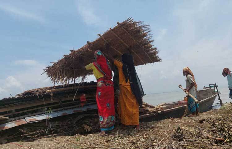 কেউ ঘর ভাঙছে, কেউ ভাঙা ঘর নৌকায় তুলে যাচ্ছেন নিরাপদ আশ্রয়ে। অনেকেই আবার গাছপালা কেটে সরাচ্ছেন। ছবি: বি.এম খোরশেদ