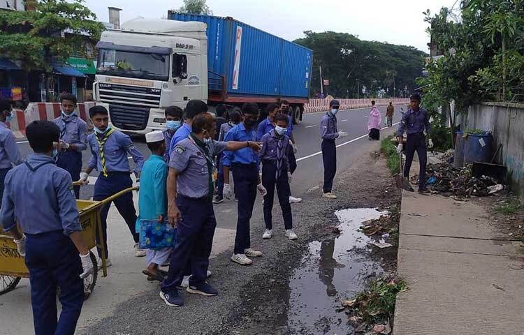 তারা সবাই মিলে সড়কের সব আবর্জনা সরিয়ে ফেলছেন। ছবি: এম মাঈন উদ্দিন