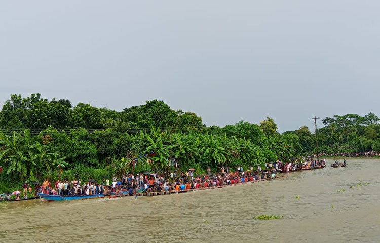 ফরিদপুরের কুমার নদে নৌকাবাইচ দেখতে মানুষের ঢল নামে। আজ বিকেলে নদীর দুই পাড়ে হাজার হাজার মানুষ উৎসবে মেতে ওঠে। নৌকাবাইচকে কেন্দ্র করে দুই পাড়ে মেলা বসে। মেলায় মিষ্টি, ইলিশসহ বিভিন্ন ধরনের মাছ, খেলনা ও খাবারের পসরা নিয়ে বসেন দোকানিরা। ছবি: এন কে বি নয়ন