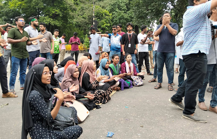 সড়কের মাঝখানে বসে, হাতে প্ল্যাকার্ড নিয়ে ও মুখে স্লোগান তুলে তারা তাদের দাবি জানিয়ে যাচ্ছেন।