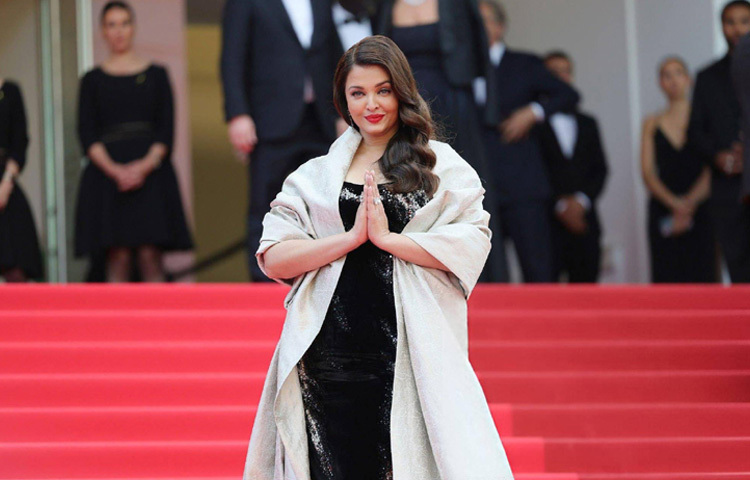 চেনা সেই ঐশ্বরিয়া, তবে সাজে নতুন চমক। ভারতীয় ডিজাইনার গৌরব গুপ্তর ডিজাইন করা এক স্ট্র্যাপলেস ভেলভেট গাউনে হাজির হন তিনি। পুরো কালো পোশাকজুড়ে ছিল রুপালি সিকুইনের কাজ, আর তার সঙ্গে ছিল কাঁধ থেকে মাটি পর্যন্ত নেমে আসা চোখধাঁধানো কেপ।