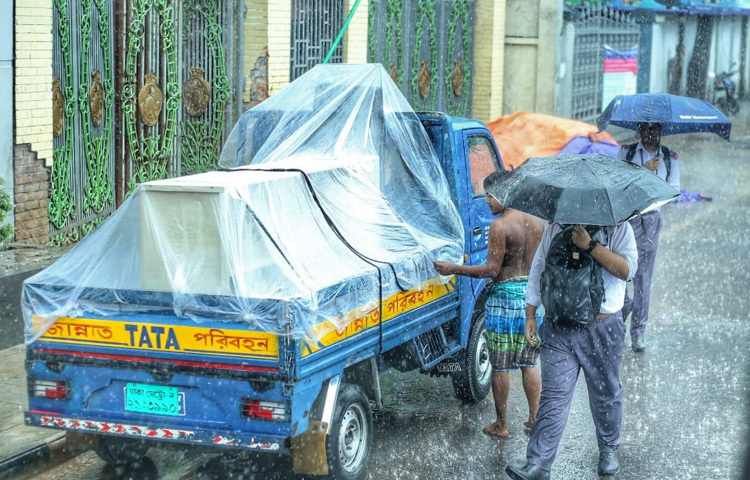 বৃষ্টির ফোঁটার তালে তালে শহরের গতি খানিকটা শ্লথ হয়ে এলেও, মানুষের তাড়া থেমে থাকেনি। ফুটপাত ধরে ছুটছে অফিসগামী কেউ, পেছনে ভিজে যাচ্ছে শার্ট-কাগজপত্র। আবার কেউ ছাতা মেলে দাঁড়িয়ে রয়েছেন রিকশার জন্য।