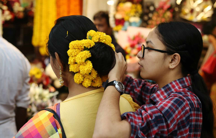 খোঁপায় ফুল সাজাতে ব্যস্ত তরুণী। ছবি: মাহবুব আলম