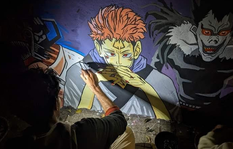 দেওয়ালে যেসব ছবি আঁকা হয়েছে সেসবের ভেতর কিছু ছবি সরাসরি বার্তা বহন করছে। যেমন রণবীর বিখ্যাত টোকাই চরিত্রকে নিয়ে আঁকা একটি দেয়ালচিত্রে ফুটে উঠছে যে টোকাই একটি কাটা গাছে হেলান দিয়ে আরাম করে শুয়ে আছে, তার চোখে ভিআর সেট, সেখানে লেখা ‘উন্নয়ন’। ছবি: গোলাম মাওলা মুরাদ