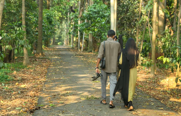 জাতীয় উদ্ভিদ উদ্যানের মনোরম পরিবেশে সময় কাটিয়ে ফিরছেন যুগল। কোনো সংকোচ ছাড়াই প্রেমিকার জুতা বহন করছেন প্রেমিক। ছবি: মাহবুব আলম