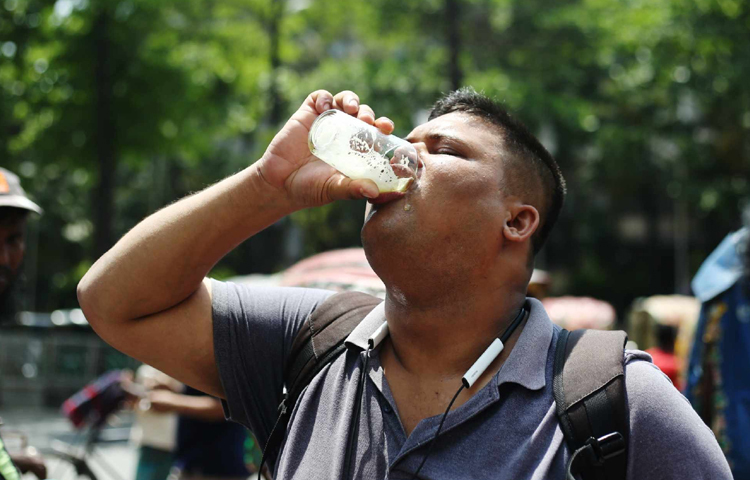 তীব্র গরমে পথ চলতে চলতে ক্লান্ত পথচারীরা রাস্তায় পাশের শরবত খেয়ে তৃষ্ণা মেটাচ্ছেন। ছবি: মাহবুব আলম