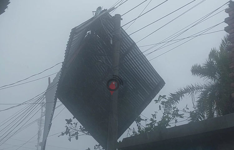 প্রচণ্ড বাতাসে ঘরের চালা উড়ে গিয়ে বিদ্যুতের খুঁটির ওপর পরেছে। এতে বিদ্যুৎবিচ্ছিন্ন রয়েছে পুরো এলাকা। ছবি: আবু হোসাইন সুমন