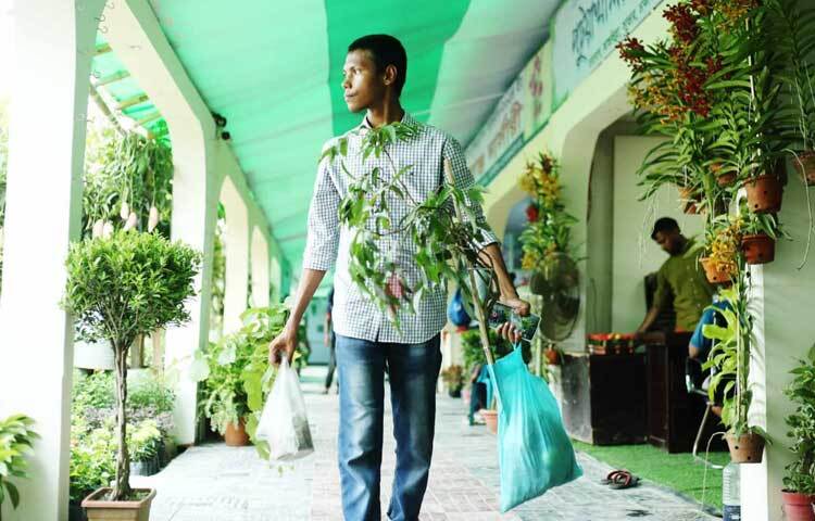 মেলা থেকে পছন্দের গাছ কিনে নিয়ে যাচ্ছেন ক্রেতা। ছবি: মাহবুব আলম