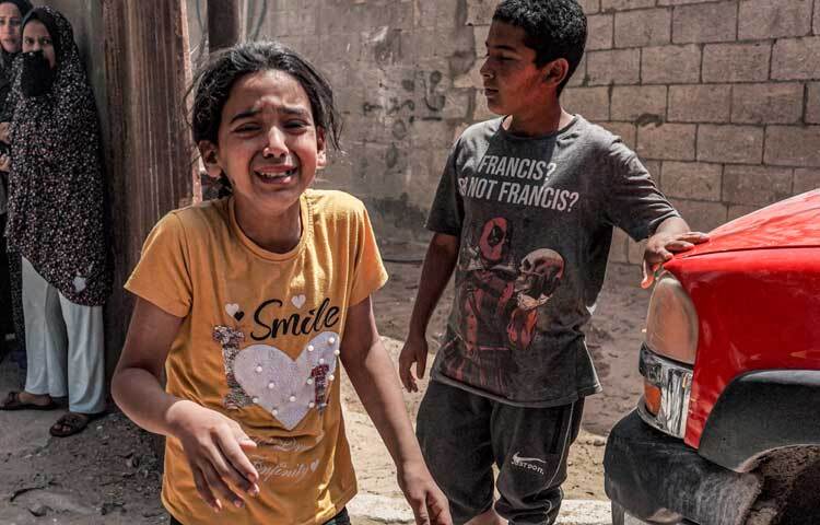 মা-বাবাকে হারিয়ে অঝোরে কাঁদছে শিশুটি। ছবি: এএফপি