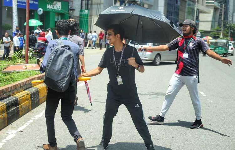 নিয়ম মেনে চলতে মানুষ ও গাড়িচালকদের বাধ্য করছেন। ছবি: মাহবুব আলম