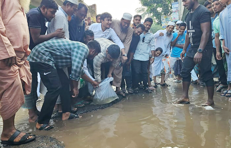 কুমিল্লার দেবিদ্বারে খানাখন্দে ভরা সড়কে মাছ ছেড়ে প্রতিবাদ জানালেন জাতীয় নাগরিক পার্টির দক্ষিণাঞ্চলের মুখ্য সংগঠক হাসনাত আবদুল্লাহ। আজ সকালে উপজেলার কাচিসার এলাকায় দে‌বিদ্বার-চা‌ন্দিনা সড়কে তিনি এভাবে প্রতিবাদ জানান। ছবি: জাগো নিউজ