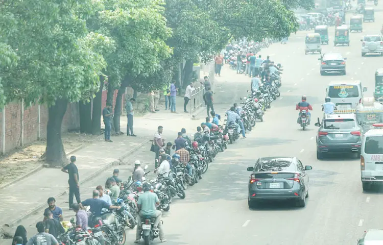 গাড়ির জন্য তেল নিতে লাইন চলে গেছে মহাখালী রেলক্রসিংয়ের কাছাকাছি। দীর্ঘসময় অপেক্ষা আর ধৈর্যের পরীক্ষা দিয়ে তেল পাচ্ছেন চালকরা। ছবিটি বিজয় সরণির ট্রাস্ট ফিলিং স্টেশন থেকে তোলা। ছবি: জাগো নিউজ