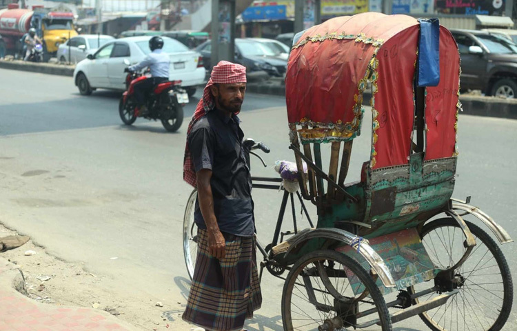 মাথায় ঘামছা বেঁধে কেউ ঢাকার তপ্ত বাতাসে বাঁচার চেষ্টা করছেন।