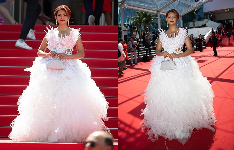 দ্বিতীয় দিনেও কান উৎসবের লালগালিচায় প্রিয়তির উপস্থিতি ছিল এক কথায় মন্ত্রমুগ্ধকর। সাদা রঙের রাজকীয় বল গাউনে ফ্রেমবন্দি হন তিনি, যা ছিল রাজহাঁসের সৌন্দর্য থেকে অনুপ্রাণিত। আইরিশ ঐতিহ্যবাহী ভাঙা হাতপাখা ও সূক্ষ্ম সাদা কাপড়ের সংমিশ্রণে তৈরি এই পোশাকে উপরিভাগে মুক্তার কারুকাজ আর নীচের দিকে ছিল রাফলের স্তরে স্তরে নকশা, যা পোশাকটিকে এনে দিয়েছে ঐশ্বর্য ও মাধুর্য। গাউনটির সৌন্দর্য আরও দৃষ্টিনন্দন করে তোলে প্রিয়তির সাজ। কানে শোভা পাচ্ছিল মুক্তা বসানো ফুলের ডিজাইনের দুল, আর স্টাইলিশ বানেও ছিল মুক্তার অলংকরণ। পুরো লুকটি পরিপূর্ণ হয় একটি ঝকঝকে সিলভার ক্লাচ হাতে নিয়ে।