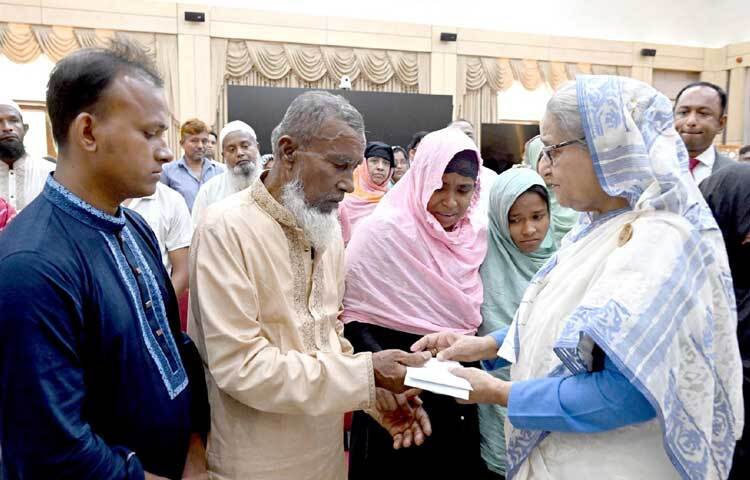 নিহতদের স্বজনদের হাতে অনুদানের চেক তুলে দিচ্ছেন প্রধানমন্ত্রী। ছবি: পিআইডি