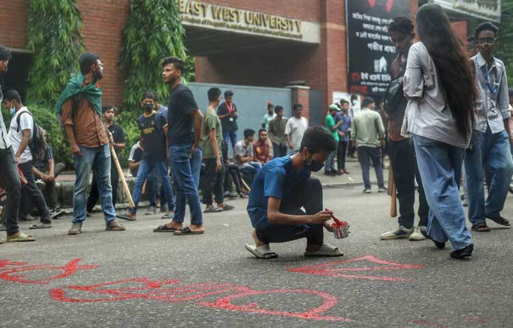 সড়কে গ্রাফিতি অঙ্কনে ব্যস্ত শিক্ষার্থীরা। ছবি: মাহবুব আলম