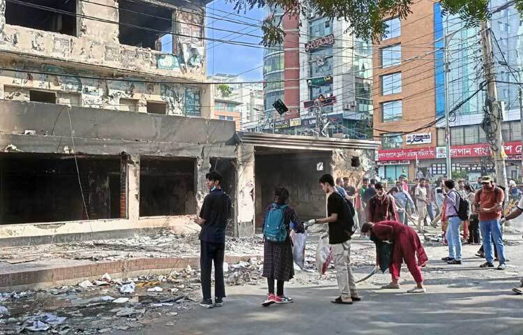 সড়ক ঝাড়ু দিয়ে পরিষ্কার করছেন তারা। ছবি: নাহিদ সাব্বির