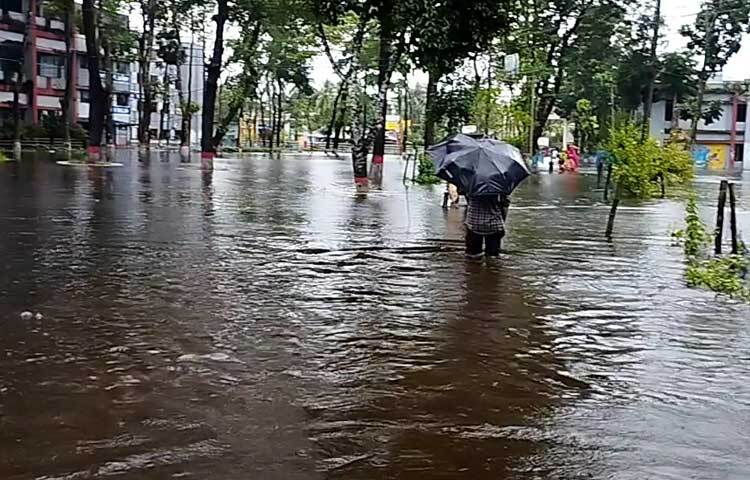 হাঁটু পানি মাড়িয়ে চলাফেরা করতে হচ্ছে ওই এলাকার বাসিন্দাদের। ছবি: ইকবাল হোসেন মজনু