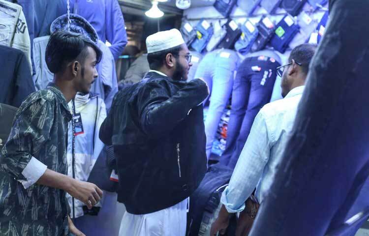 কেনার আগে নতুন পোশাকে নিজেকে কেমন লাগছে তাই দেখে নিচ্ছেন এক যুবক।