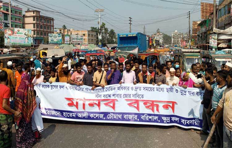 স্বল্পমূল্যে স্টল বরাদ্দ, টেন্ডার বাতিল করে নতুন টেন্ডার করাসহ তিন দফা দাবিতে বরিশাল-কুয়াকাটা মহাসড়ক অবরোধ করে মানববন্ধন করেছেন বরিশালের চৌমাথা বাজারের ক্ষুদ্র ফল ব্যবসায়ীরা। ছবি: শাওন খান