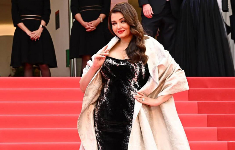 ঐশ্বরিয়ার এই লুকে আরও নজর কেড়েছে ‘রেড লিপ’ মেকআপ। তাতে তার চেহারার গ্ল্যামার যেন দ্বিগুণ হয়ে উঠেছে। চুলে রাখা হয়েছে সফট কার্ল, সাজে যুক্ত করা হয়েছে মিনিমাল হীরার দুল ও আংটি।