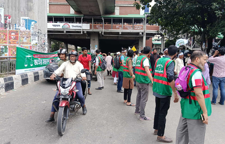 আইনশৃঙ্খলাবাহিনীর পাশাপাশি সড়কে কাজ করছেন জামায়াতের স্বেচ্ছাসেবীকর্মীরা। ছবি: রায়হান আহমেদ