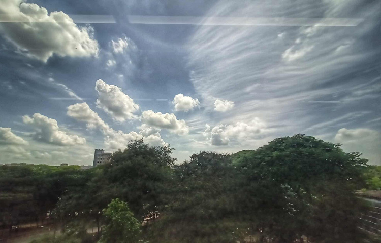 শাহবাগ এলাকা থেকে দেখা যায় সাদা মেঘের ভেলা গড়িয়ে নিচ্ছে আধুনিক শহরের ইটের গাঢ় রঙের সঙ্গে এক মধুর মিলন।