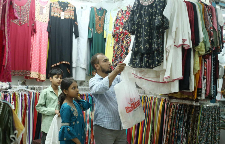 মেয়ের জন্য জামা পছন্দ করছেন বাবা। ছবি: মাহবুব আলম