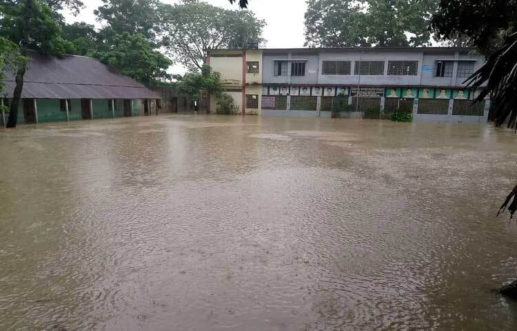 রাস্তায় হাঁটুপানি উঠে যাওয়ায় শিক্ষার্থীরা স্কুল-কলেজে যেতে পারছে না।  ছবি: আবদুল্লাহ আল-মামুন