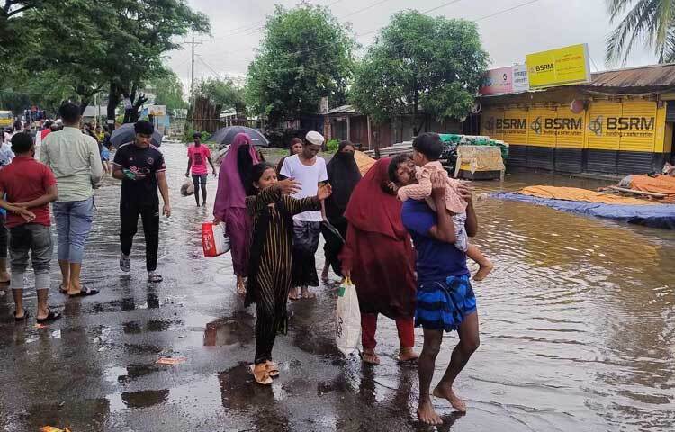 অনেকে ছেলে-মেয়েদের সাথে নিয়ে আশ্রয়কেন্দ্রে ছুটছে। ছবি: এম মাঈন উদ্দিন