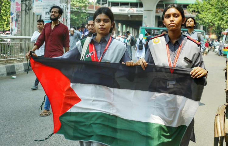 ফিলিস্তিনের পতাকা হাতে মিছিলে অংশ নিয়েছেন দুই তরুণী।